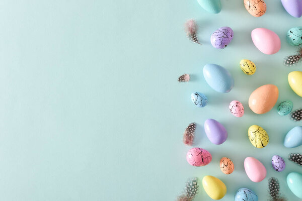 Easter card with bed-colored eggs and feathers with a copy of the place for the text. Banner for Easter. Festive background. Copy space. Flat lay, top view.