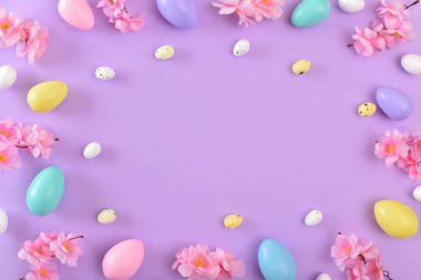Mor arka planda Paskalya yumurtaları olan bir arka plan. Paskalya tatili için bahar arkaplanı. Uzayı kopyala Düz yatış, üst görünüm.