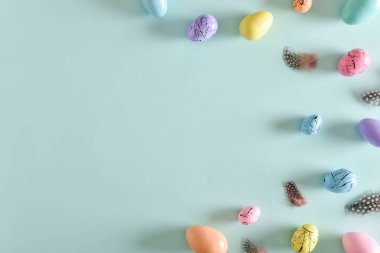 Paskalya kartı, yatak rengi yumurtalar ve tüy ile birlikte mekanın bir kopyası. Paskalya bayrağı. Şenlik arka planı. Uzayı kopyala Düz yatış, üst görünüm.