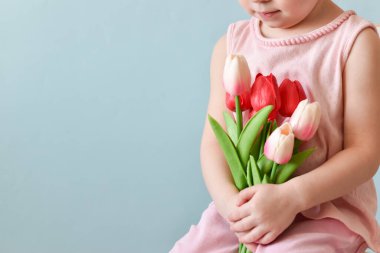 Seçici odaklanma. Bir çocuğun elinde bir buket güzel lale. Anneler Günü konsepti, Kadınlar Günü. Boşluğu kopyala