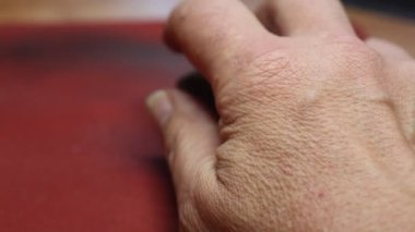 Hand operates computer mouse on the red pad