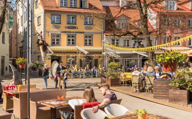 Riga, Letonya - 30 Nisan 2018: Eski şehir Riga, Letonya 'nın tarihi merkezindeki açık hava barında eğlenen insanlar