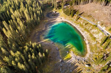 İtalya 'nın güneyindeki Dolomites, Bolzano eyaleti Nova Levante' de bulunan Carezza o Karersee adlı küçük bir alp gölünün havadan görünüşü