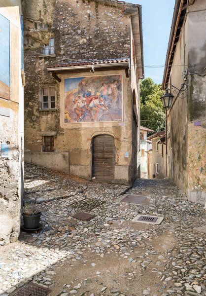 Arcumeggia, Varese, Italy - September 7, 2022: Narrow cobblestones streets with paintings on walls in ancient painted village Arcumeggia in province of Varese, Lombardy, Italy