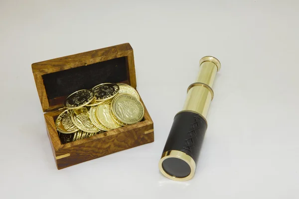 Antique brass telescope with gold coins — Stock Photo, Image