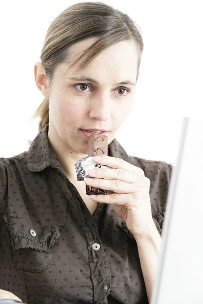 Frau isst einen Schokoriegel — Stockfoto
