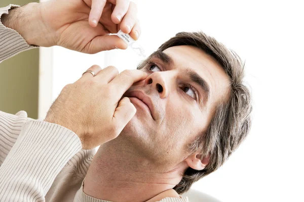 Man använder eye lotion — Stockfoto