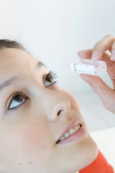 MUJER USANDO LA LOCIÓN DE LOS OJOS — Foto de Stock