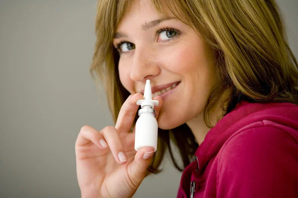 Vrouw met behulp van neus spray — Stockfoto