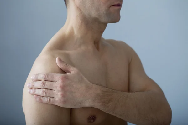 Человек с болью в плече — стоковое фото