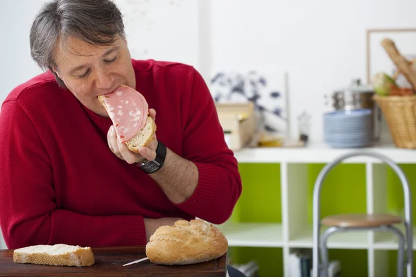 Un homme qui mange de la viande de porc — Photo