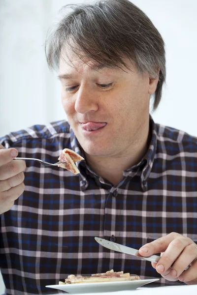 Un homme qui mange de la viande de porc — Photo