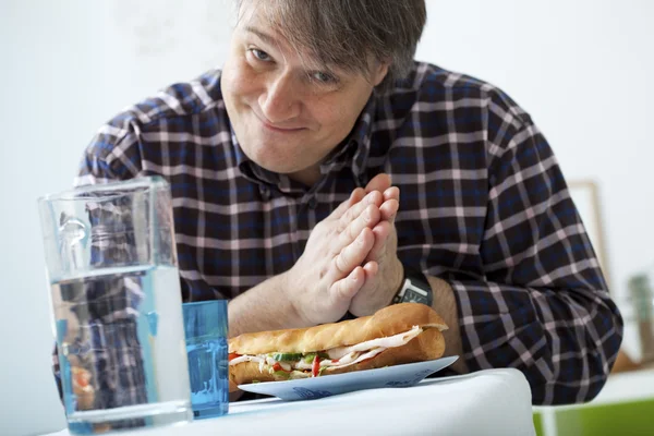 Muž jí sendvič — Stock fotografie