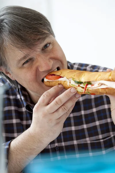 Homem comendo um sanduíche — Fotografia de Stock