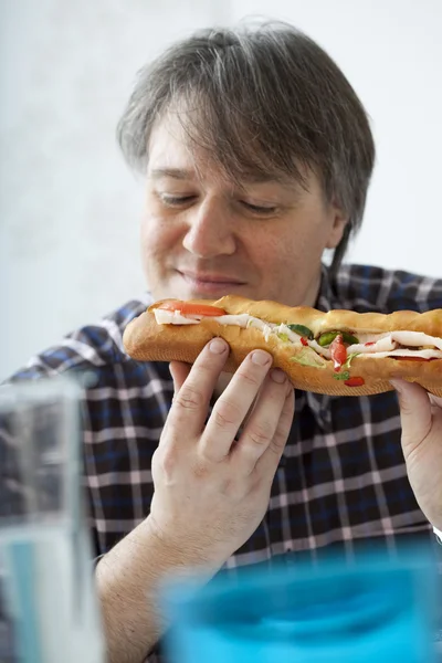 Homem comendo um sanduíche — Fotografia de Stock