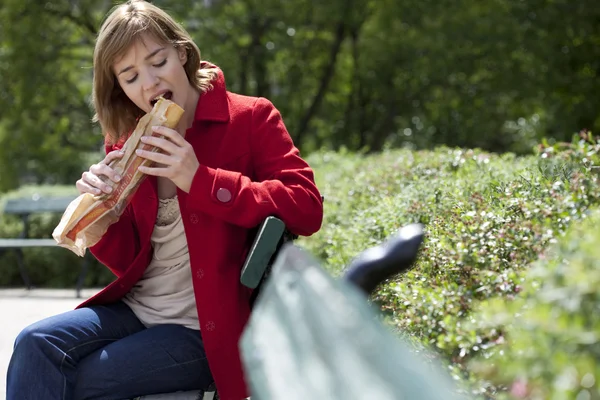 WOMAN comendo um sanduíche — Fotografia de Stock