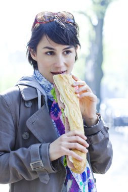 Sandviç yiyen kadın.