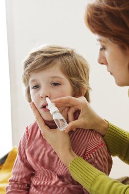 Çocuk burun spreyi kullanarak