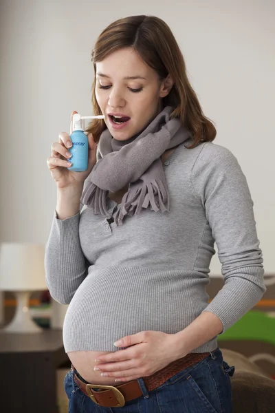 Zwangere vrouw met behulp van spray — Stockfoto