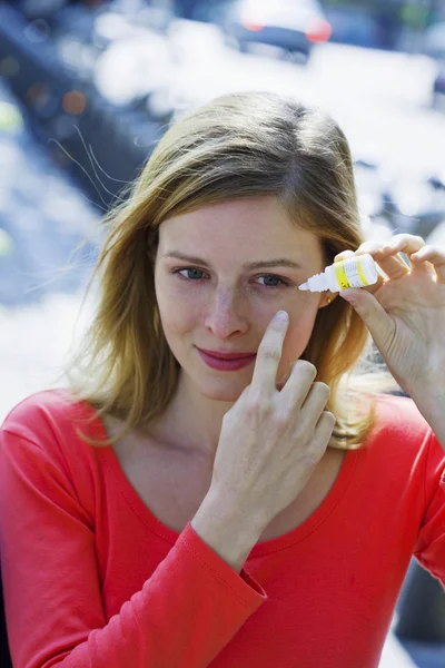 Vrouw met behulp van oog lotion — Stockfoto