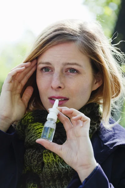 Vrouw met behulp van neus spray — Stockfoto