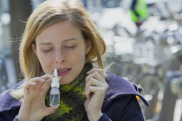 WOMAN USING NOSE SPRAY — Stock Photo, Image