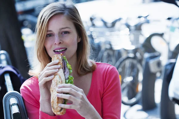 WOMAN EATING A SANDWICH — Stock Photo, Image