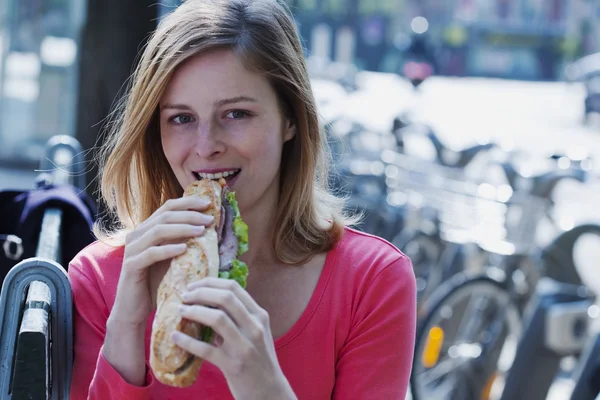 Kobieta jedząca kanapkę — Zdjęcie stockowe