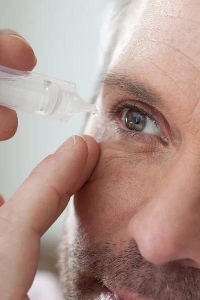 Man met oog lotion — Stockfoto