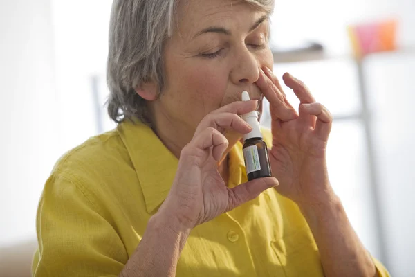 Persona de edad avanzada usando spray nasal —  Fotos de Stock