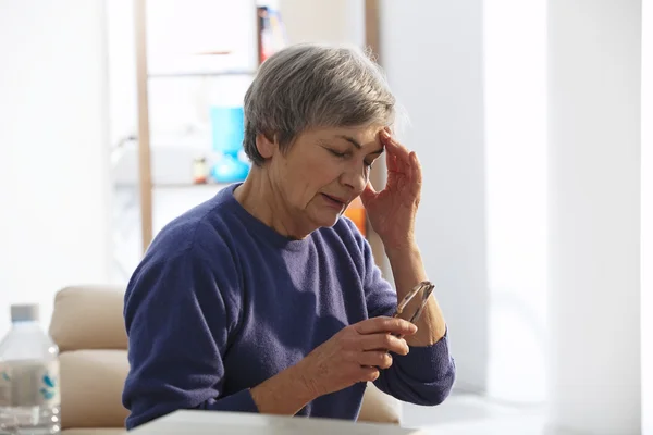 Ältere Person mit Kopfschmerzen — Stockfoto
