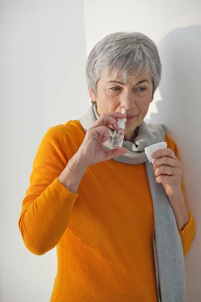 ELDERLY PERSON USING NOSE SPRAY — Stock Photo, Image