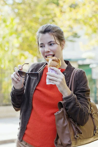 Vrouw eten croissant — Stockfoto