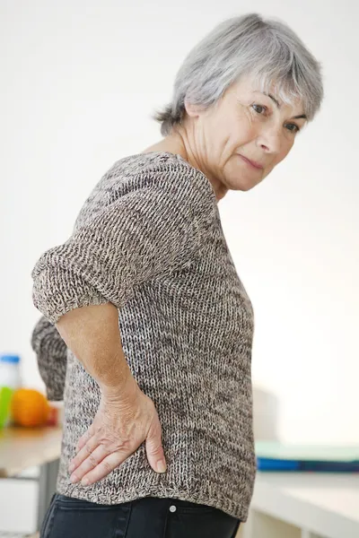 LOWER BACK PAIN IN ELDERLY PERS. Stock Photo