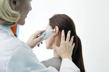 Doktor bir kadının sıcaklığını ölçer