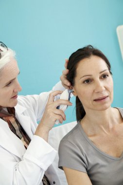 Doktor bir kadının sıcaklığını ölçer