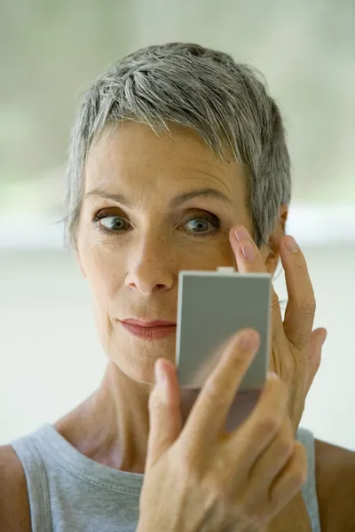 Oudere vrouw zetten op make-up — Stockfoto