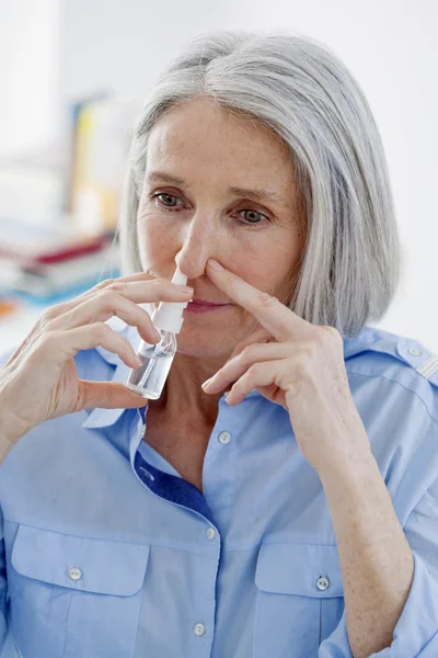 Äldre person som använder nässpray — Stockfoto