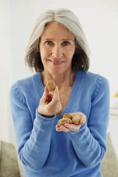 Ältere Person isst Trockenobst — Stockfoto