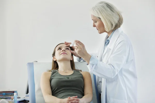 MUJER USANDO LA LOCIÓN DE LOS OJOS — Foto de Stock