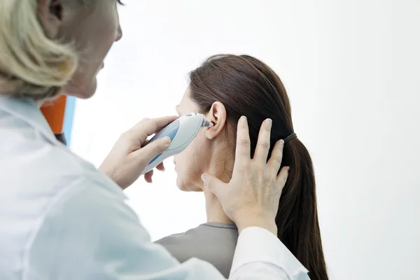 Médico mede a temperatura de uma mulher — Fotografia de Stock