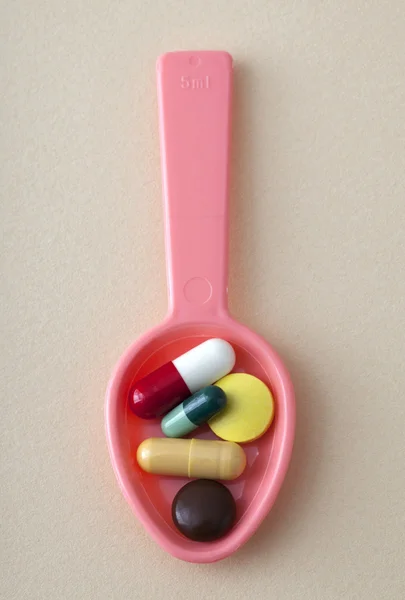 Tablets and capsules in a spoon — Stock Photo, Image