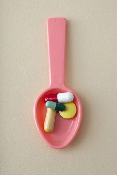 Tablets and capsules in a spoon — Stock Photo, Image