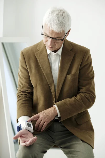 Elderly man measures pressure — Stock Photo, Image