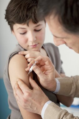 Doktor enjeksiyon çocukla koyar