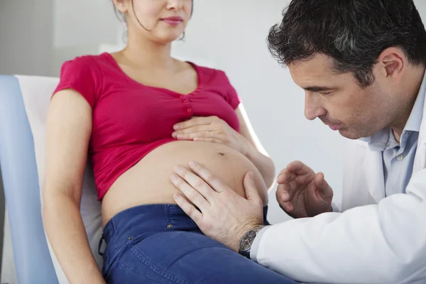 Těhotná žena prohmatání břicha — Stock fotografie