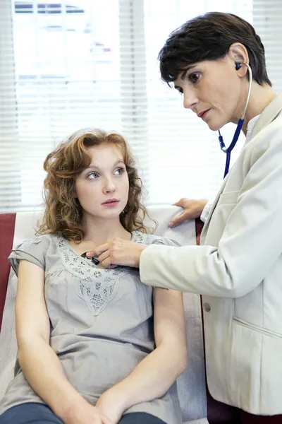 Doktor hastaya bir stetoskop ile dinler. — Stok fotoğraf