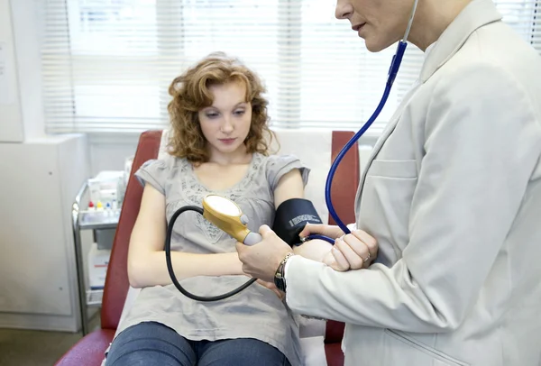 Il medico misura la pressione del paziente — Foto Stock