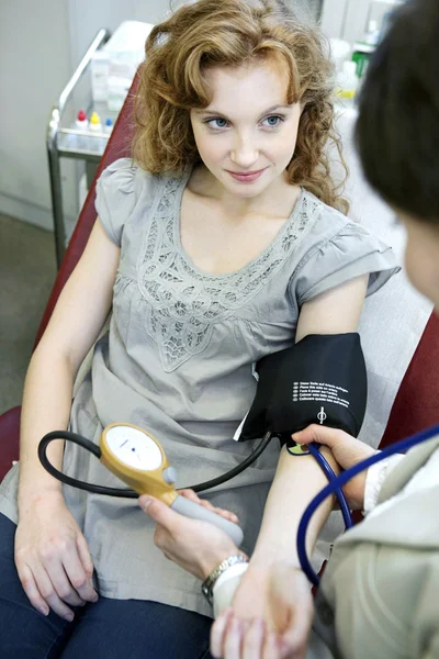 Donna medico misura la pressione — Foto Stock