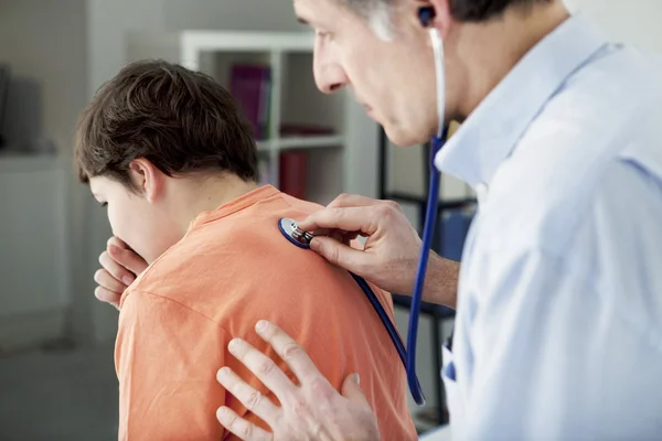 Arzt hört einem Jungen zu — Stockfoto